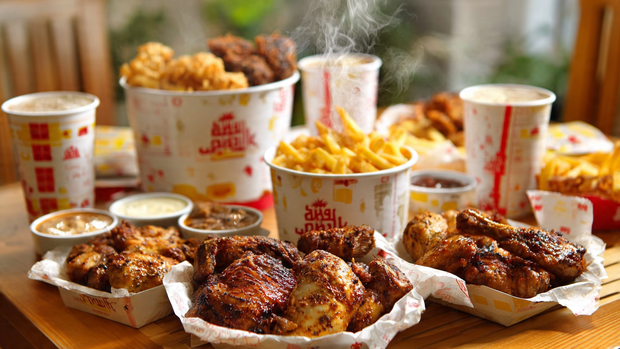 Albaik BBQ Baik family bucket with chicken, large fries, garlic dip, and drinks for four.