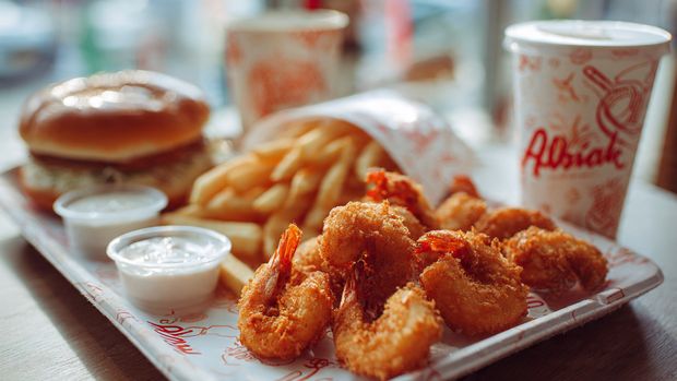 Fried shrimp, fries, bun, sauces, Albaik logo tray, Saudi flag backdrop